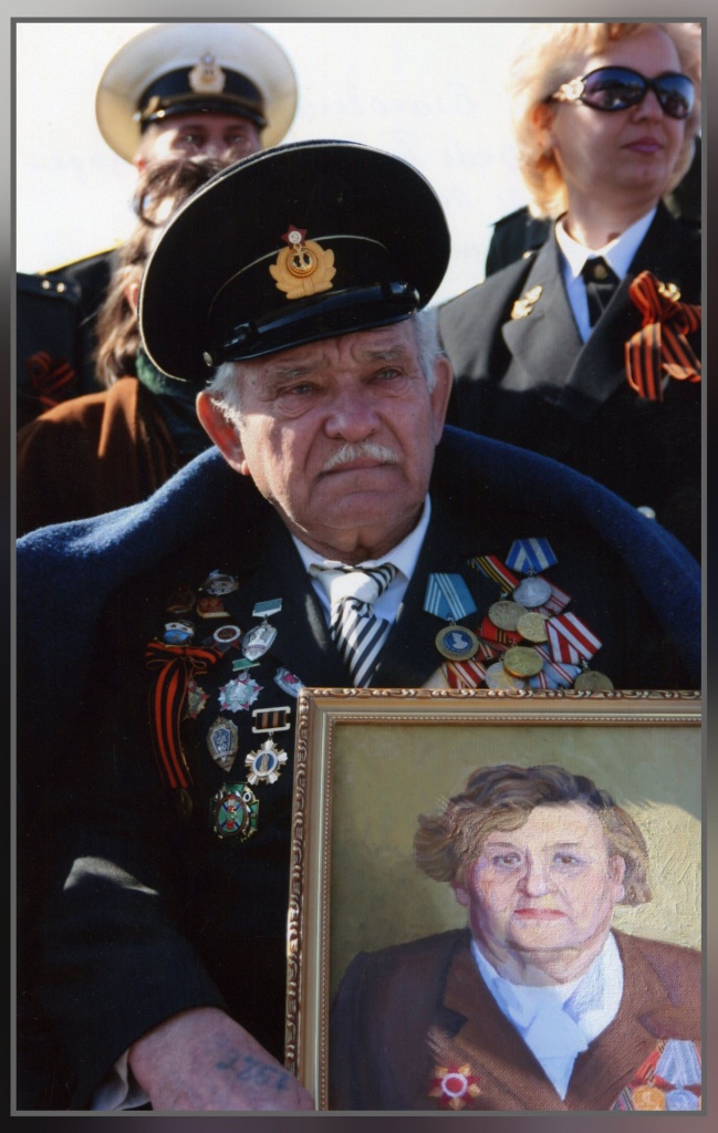 (автор не известен) Виталий Павлович Толстенко с портретом жены на площади победы. г. Благовещенск 2009 год.jpg